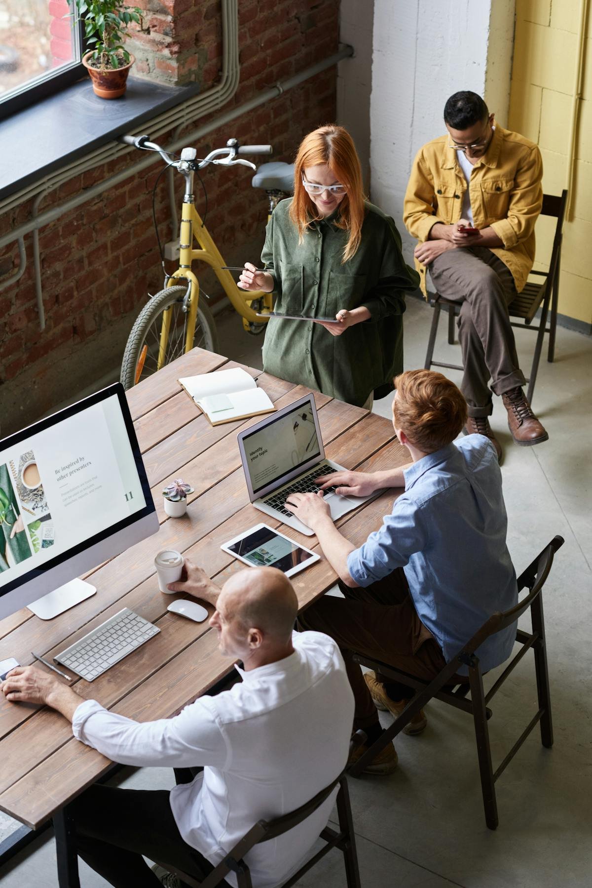 Modern office team collaborating around a shared workspace with laptops and devices