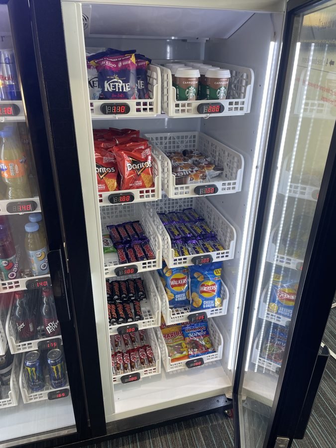 Vending machine snack shelves stocked with Doritos Kettle Chips Starbucks and chocolate bars with digital pricing